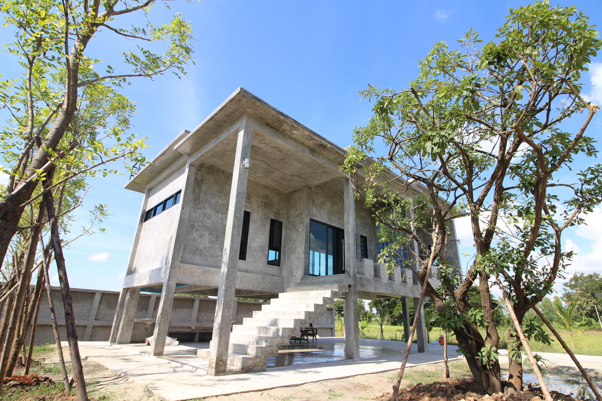 Concrete house on stilts with rural vibe