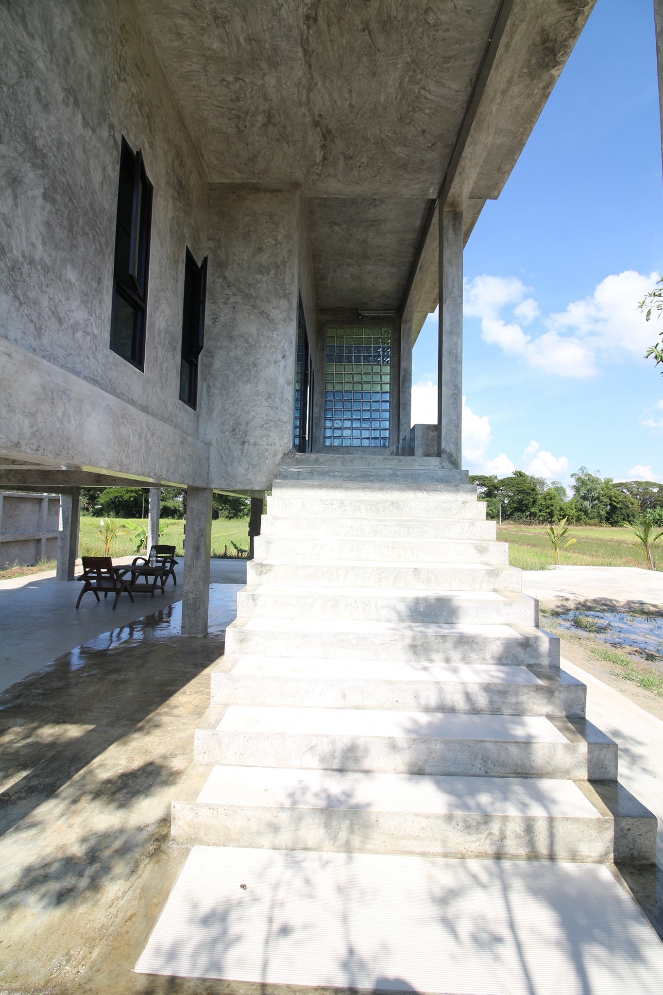 Concrete house on stilts with rural vibe